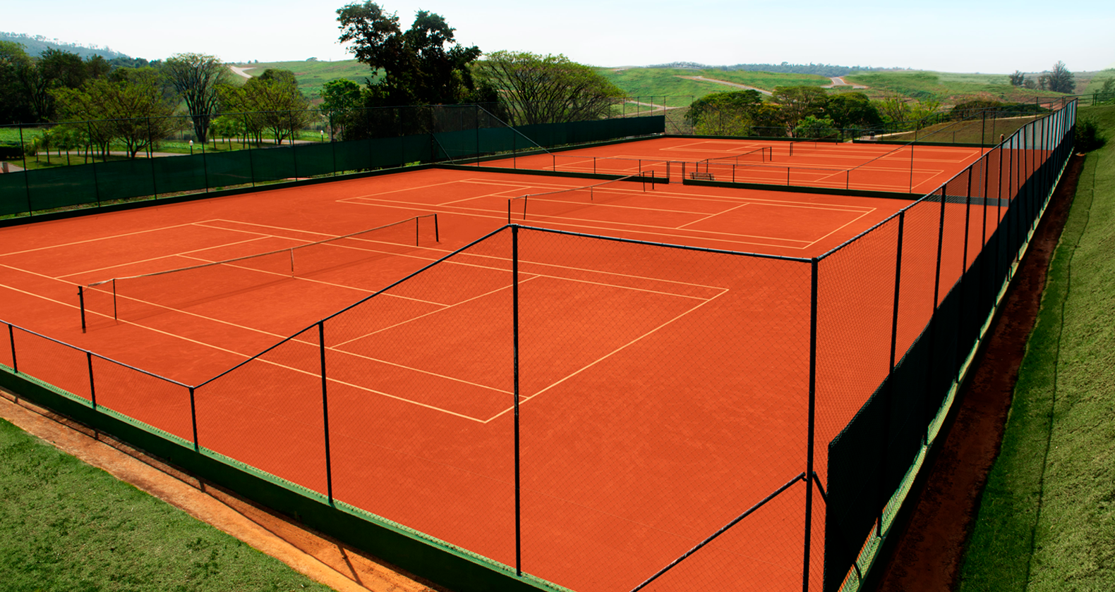 Quadras de tênis de saibro com vista para o campo