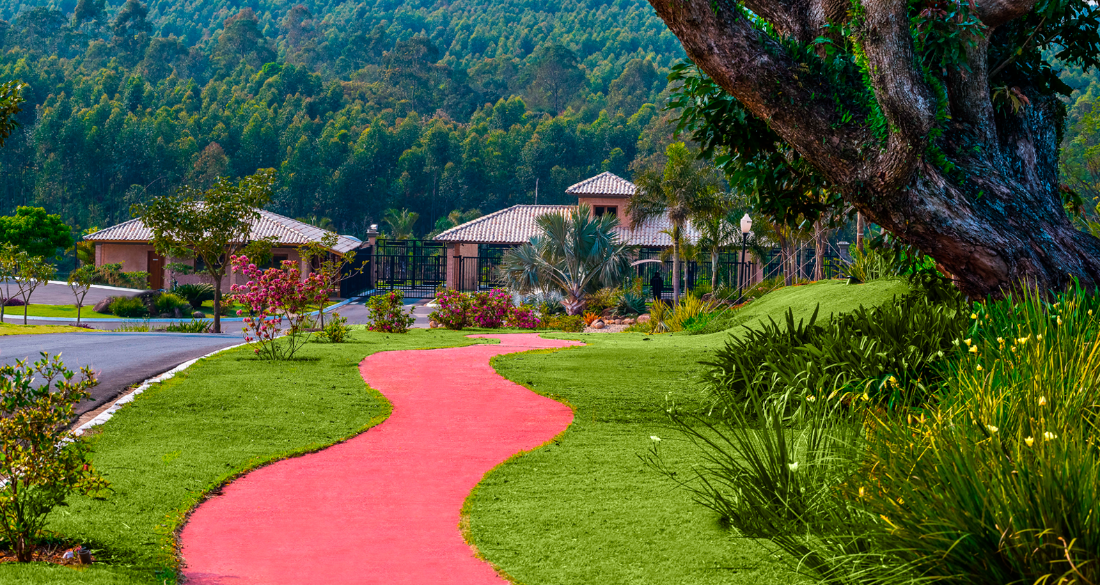 Entrada do condomínio com paisagismo tropical